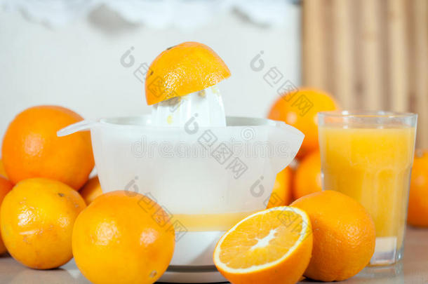 桌子上的手榨汁机附近有几个橘子。