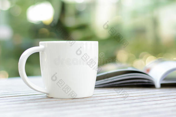 咖啡杯与书在木桌上模糊的波基背景