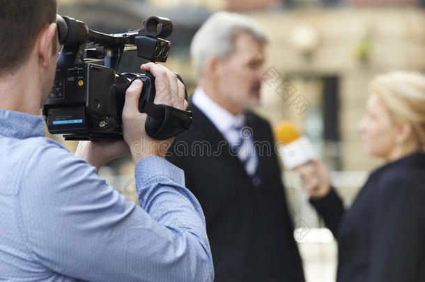 摄影师录制女记者采访商人