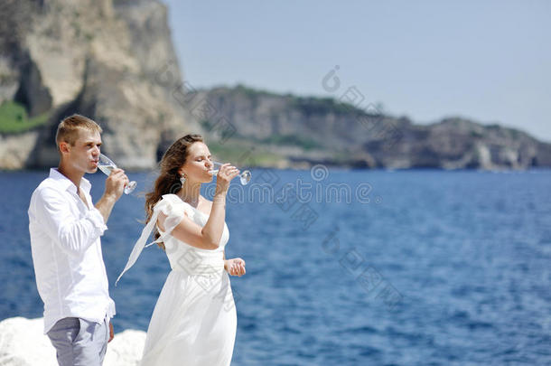 一对夫妇在婚礼当天在意大利那不勒斯海附近喝香槟