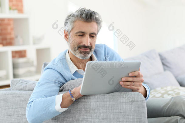 时尚成熟的男人用数字平板电脑发送电子邮件