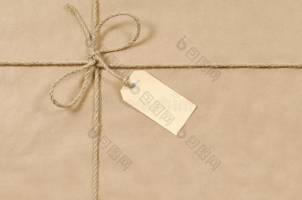 用绳子或绳子绑住的棕色纸包裹背景，礼品标签或标签，复制空间