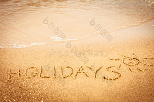 假日这个词写在沙滩上的沙滩上
