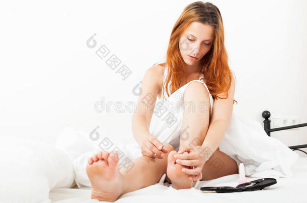 红发女人看着她的脚趾甲