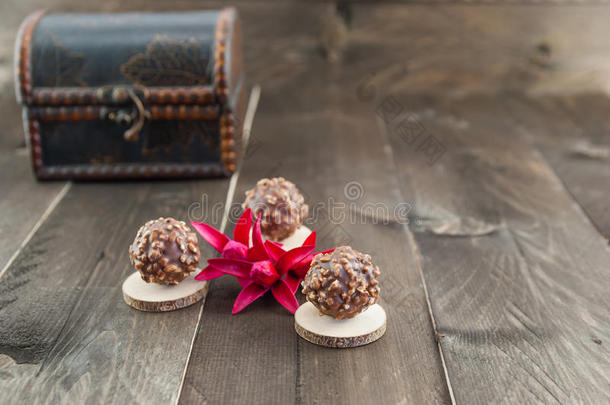 木制背景上有花生片的巧克力糖果