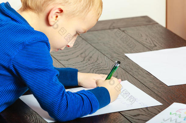 男孩用钢笔<strong>写作业</strong>。在家里。