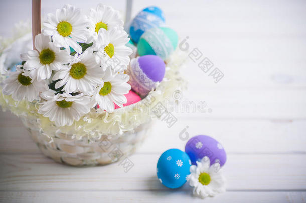 复活节礼物篮，白色的花和彩色的鸡蛋在木制背景上春天的灵感
