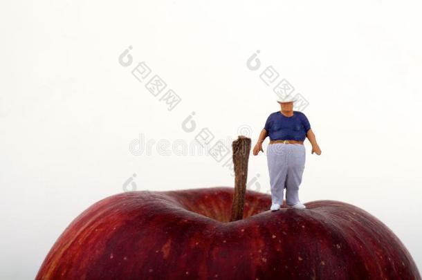 一个胖男人在一个红苹果的顶部