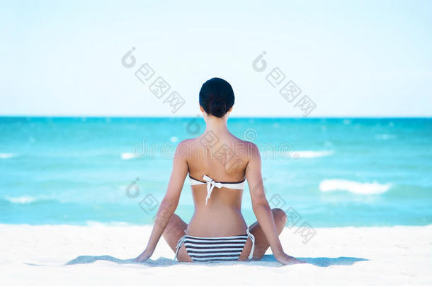 一个年轻女人在海滩上放松的背影