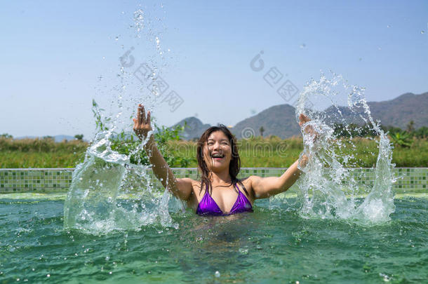 亚洲女人在游<strong>泳池里玩耍</strong>和飞溅