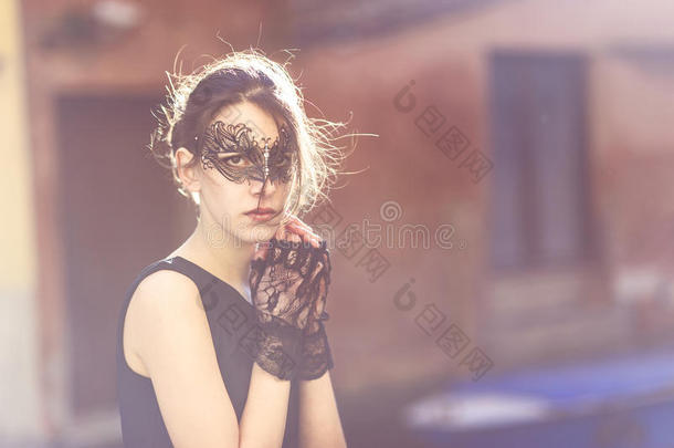 优雅的女人戴着化装面具和手套