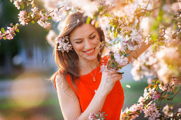 美丽的女人在开花的春天花园