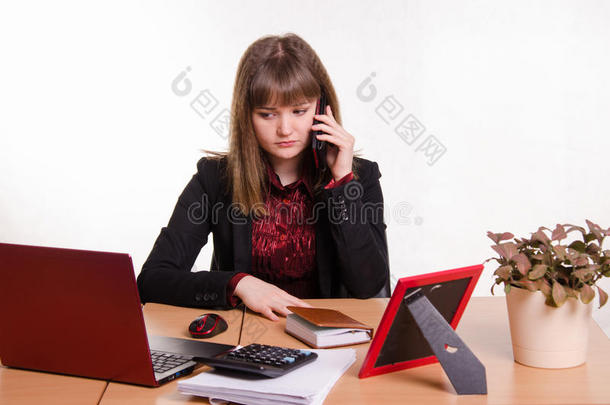 女孩在办公桌<strong>后面</strong>打电话听朋友说话