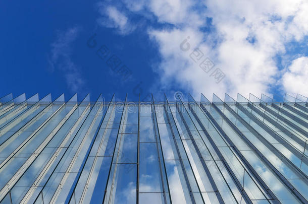 多云的天空反射在一座现代建筑的玻璃墙上