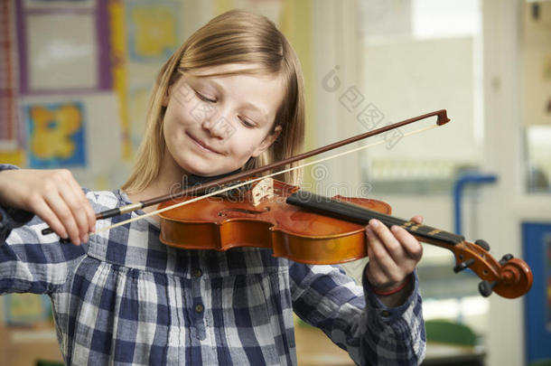 在学校<strong>音乐课</strong>上学习拉小提琴的女孩