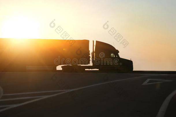 日落时卡车在高速公路上行驶