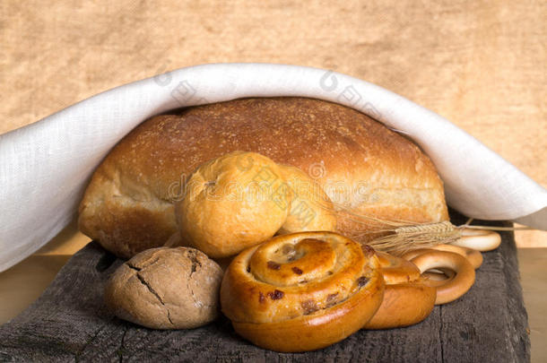 面包品种和小麦耳朵在一张旧的木制桌子上
