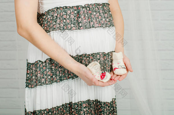 孕妇手中的婴儿袜子