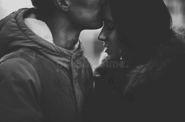 亲密的情侣形象，男人亲吻女人。 使用过滤器Instagram黑白照片。