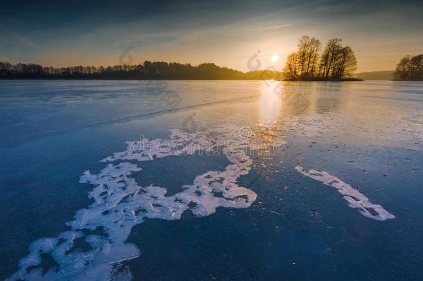 日出或日落时结冰的湖。 冬天宁静的风景。