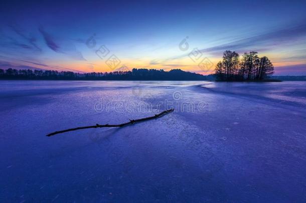 日出或日落时结冰的湖。 冬天宁静的风景。
