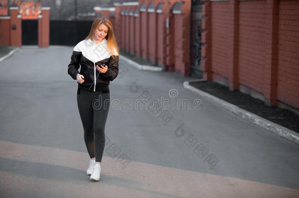 漂亮的运动女孩在街上在街上行走