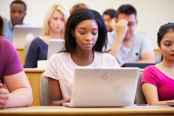 女大学生在讲座中使用笔记本电脑