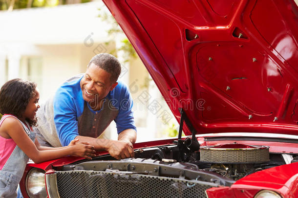 祖父和孙女正在修理汽车