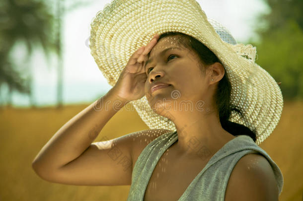 在炎热阳光明媚的夏天，亚洲女人在户外戴着帽子