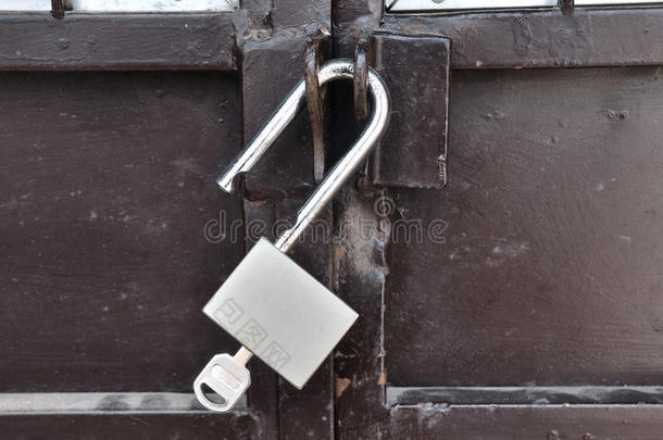 带挂<strong>锁</strong>的棕色钢门，未<strong>上锁</strong>。