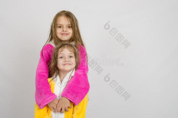 穿着浴袍的女孩抱着她妹妹的浴袍