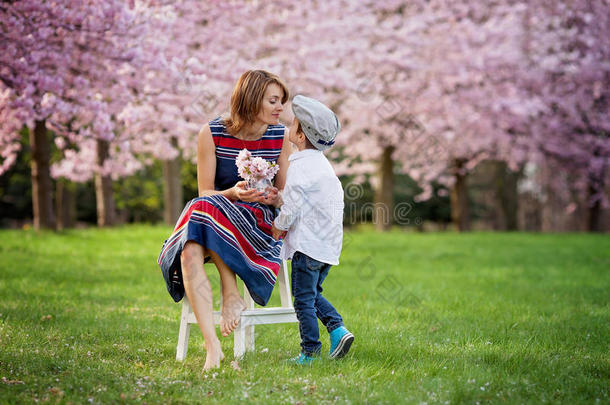 春天公园里美丽的孩子<strong>和</strong>妈妈，<strong>鲜花和礼物</strong>。母亲