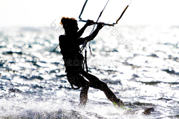 一个年轻的女风筝冲浪者骑在太阳下