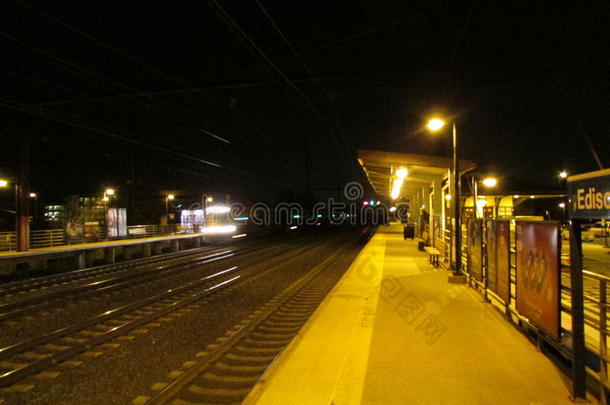 爱迪生火车站站台左边有接近的火车，右边有爱迪生标志。
