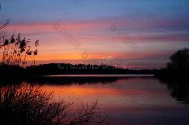 平静的湖面反射着夕阳的天空