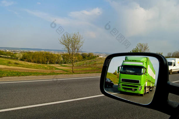 绿色，一辆移动的卡车在镜子的反射中相关联