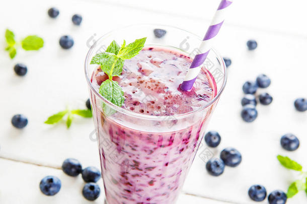 蓝莓冰沙放在一个玻璃罐里，里面放着一根稻草和一根薄荷枝