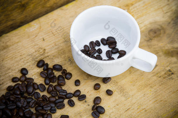 <strong>咖啡豆</strong>背景在木制，新鲜<strong>咖啡豆</strong>与<strong>咖啡杯</strong>在木制背景，饮用背景