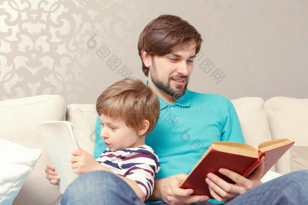 父亲和儿子读一<strong>本书</strong>或平板电脑