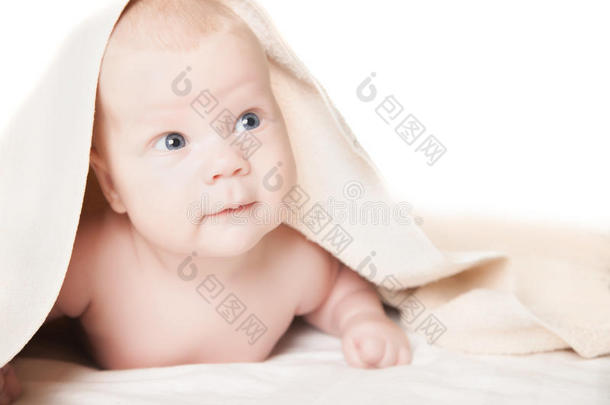 洗澡后躺在毛巾下面的可爱宝宝