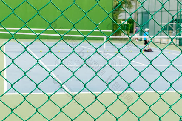 具有网球场背景的绿线围栏