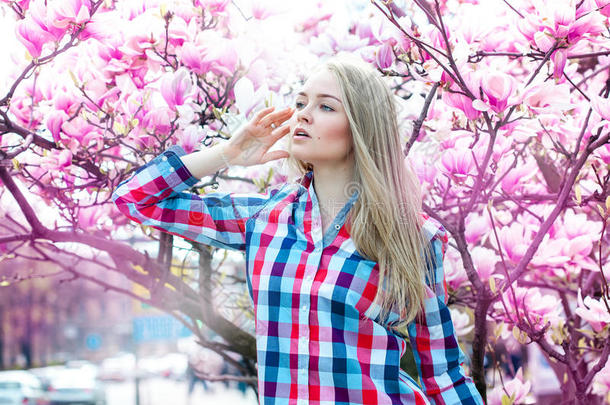 梦想着年轻的金发女人带着花看着远方