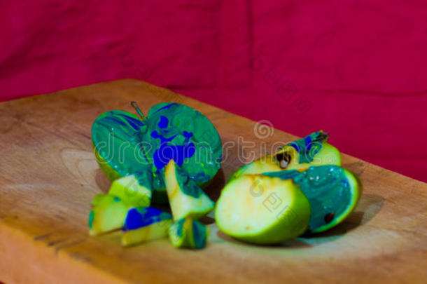 木表面涂有蓝色和绿色油漆的苹果切片的组成