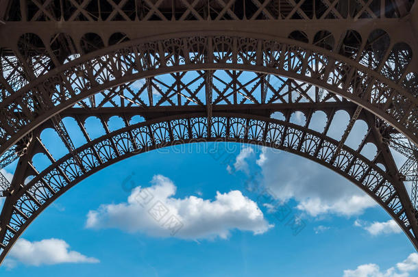 埃菲尔铁塔特写拱形框架在蓝色多云的天空在巴黎法国