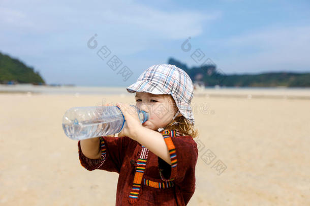 热带海滩的孩子，喝瓶装水