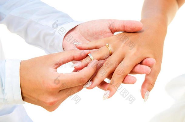 新郎给他的新娘一个<strong>订婚戒指</strong>，在拱门下装饰着沙滩上的鲜花。 婚礼开始了