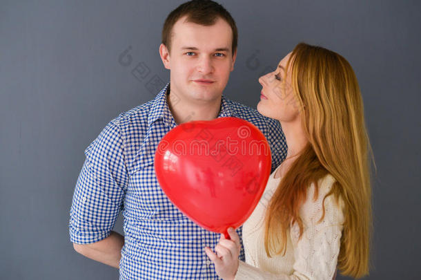 美丽的夫妇爱上了红色气球心形情人节，灰色背景