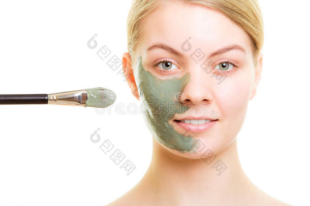 皮肤护理。女人在脸上涂泥巴面膜。