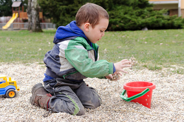 孩子在公园玩玩具和石头