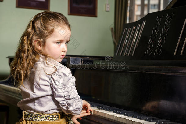 可爱的小女孩在<strong>音乐学校</strong>弹大钢琴